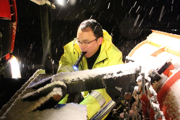 風雪中，馬巢公司夜班除雪隊員李夫勝正在調試除雪鏟大燈.jpg